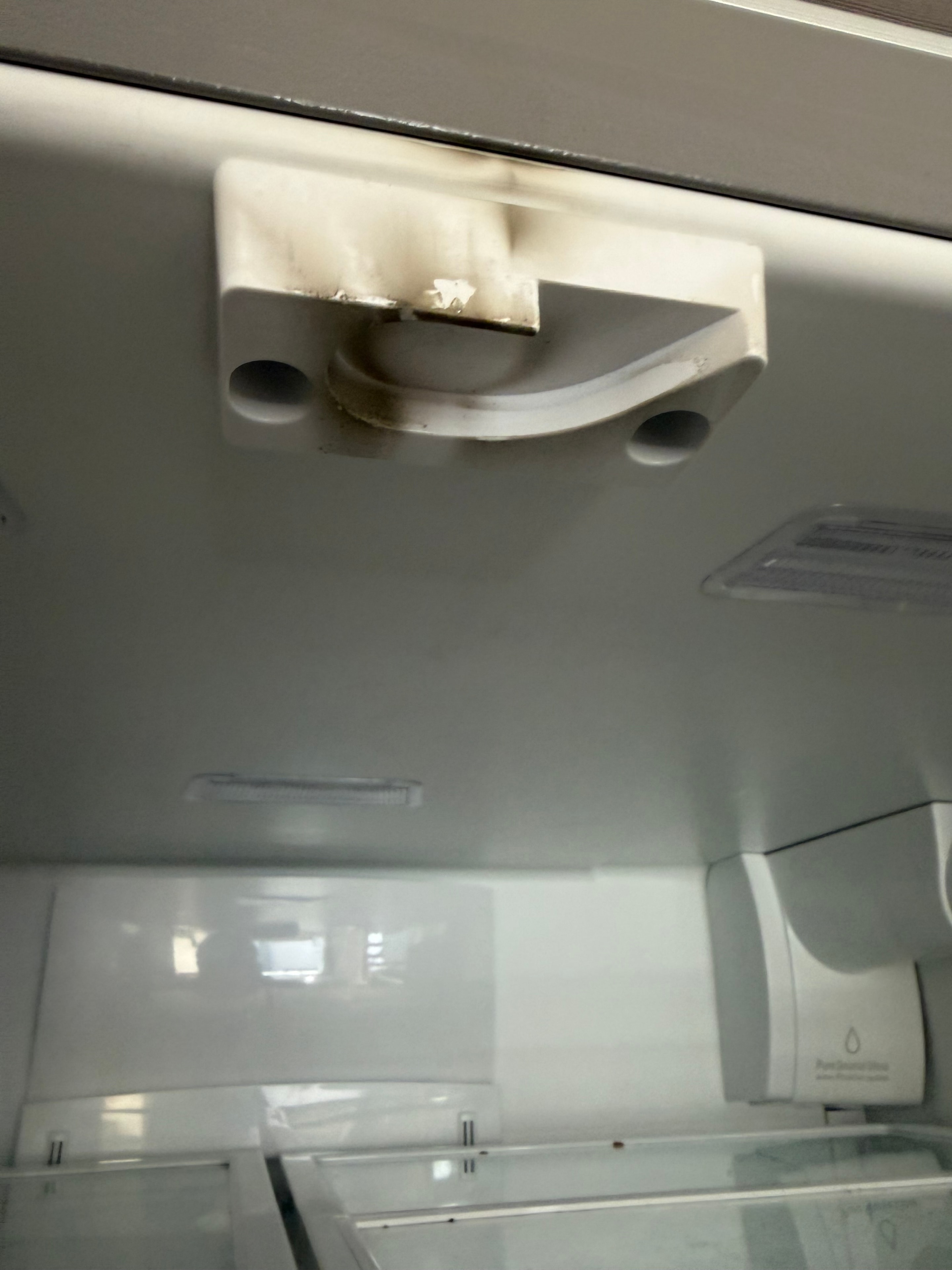 Front view of the heat-damaged Frigidaire refrigerator mullion showing discoloration from the electrical arcing event