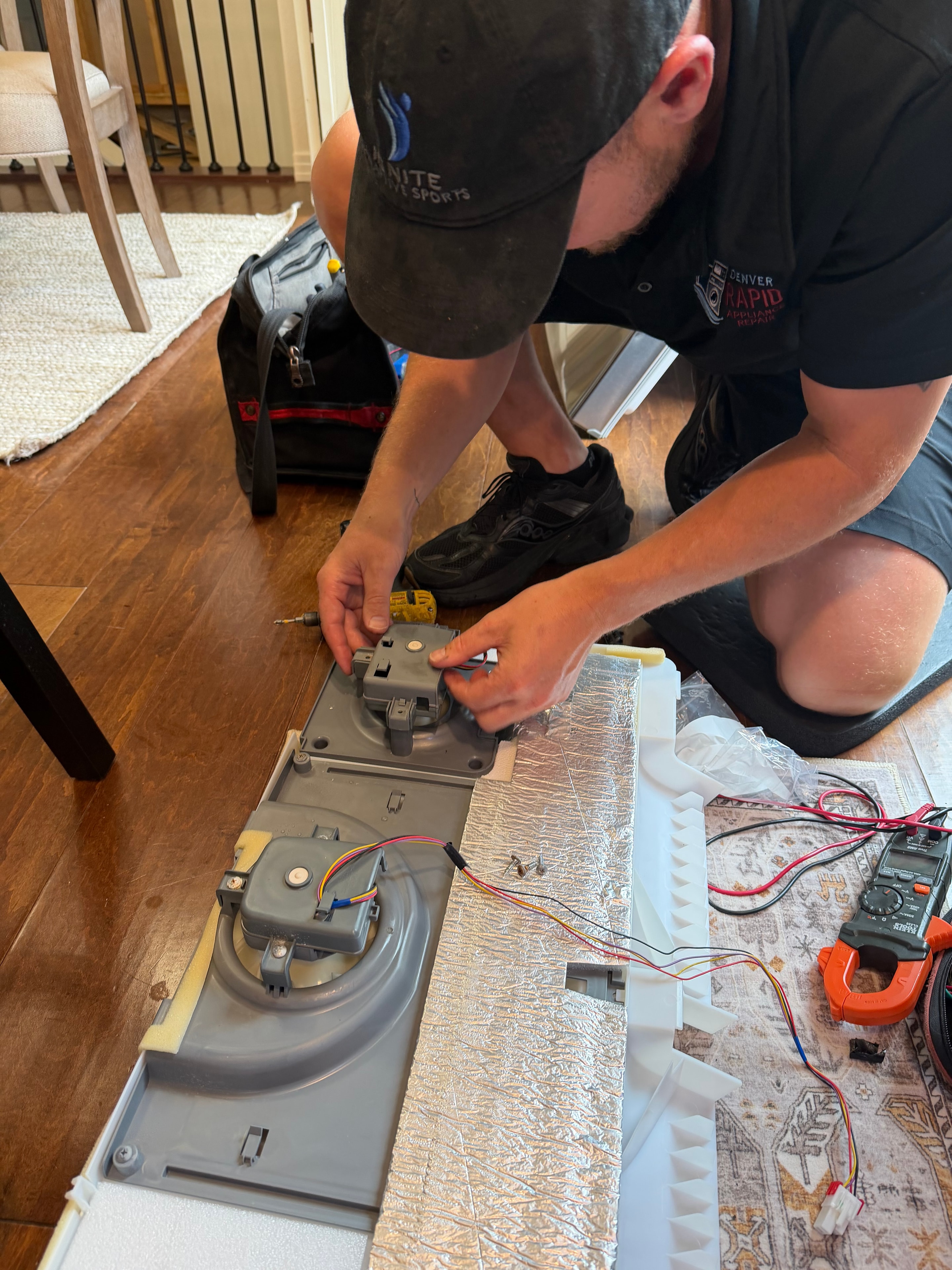 Technician installing new OEM LG evaporator fan motor EAU65058313 into ice room housing