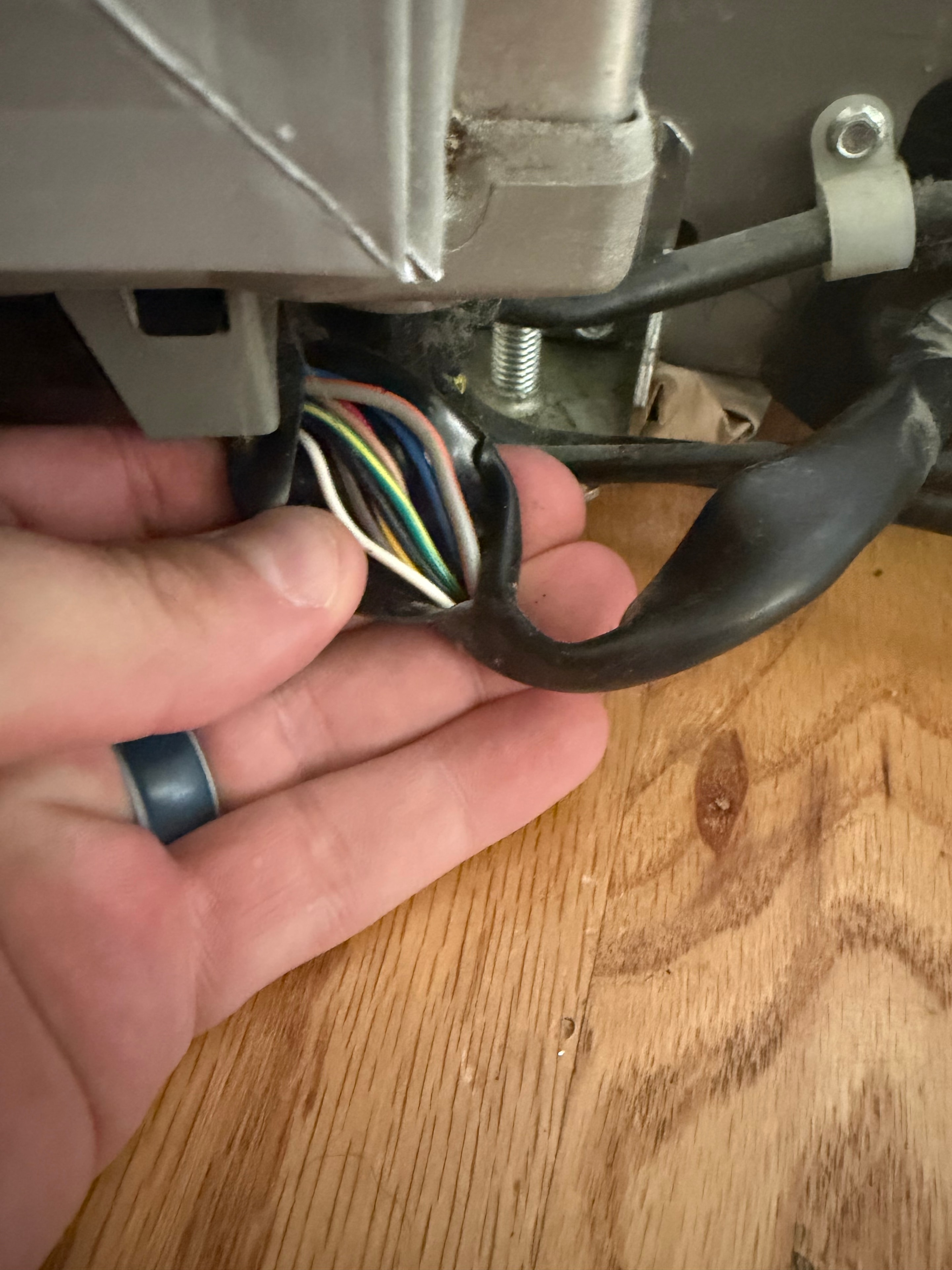 Technician inspecting the lower freezer door wiring harness on Whirlpool refrigerator — Skyland Denver
