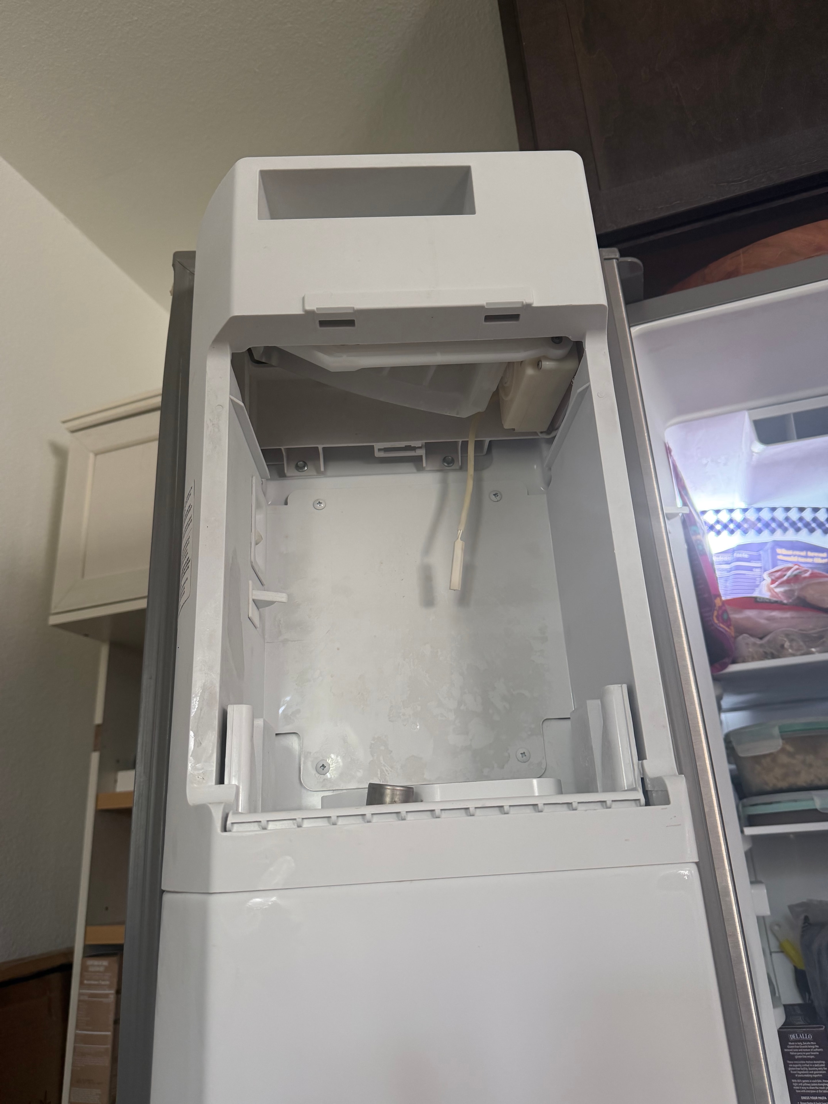 Ice bucket removed from Whirlpool side-by-side refrigerator for inspection — Skyland Denver